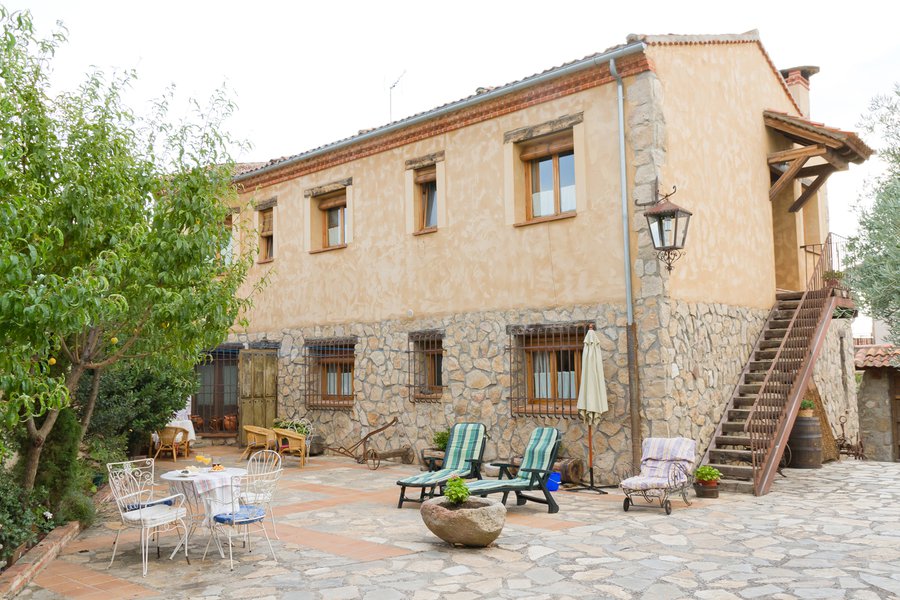 Patio con muebles de jardín, pilón y plantas de paisajismo